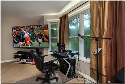 a room with a television and a desk with a chair at Modern home near Cleveland in Seven Hills
