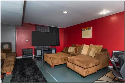 a living room with a couch and a flat screen tv at Modern home near Cleveland in Seven Hills
