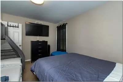 a bedroom with a bed and a flat screen tv at Modern home near Cleveland in Seven Hills