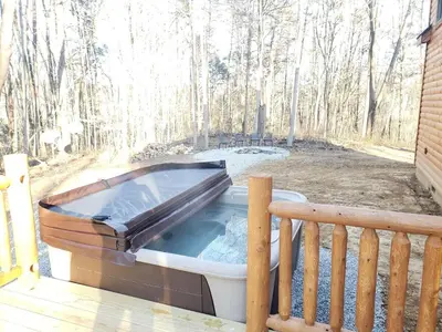 a hot tub sitting on a porch with a bench at King of Hearts in Rockbridge