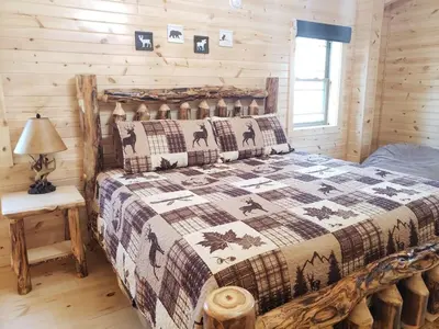 a bedroom with a bed in a log cabin at King of Hearts in Rockbridge