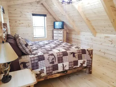 a bedroom with a bed in a log cabin at King of Hearts in Rockbridge