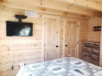 a bedroom with a bed and a flat screen tv at King of Hearts in Rockbridge