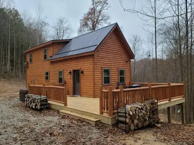 a large wooden cabin with a deck and a house at Queen of Hearts in Rockbridge
