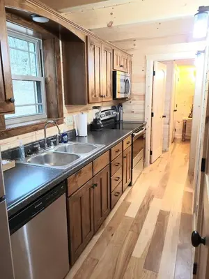 a kitchen with wooden cabinets and a stainless steel sink at Queen of Hearts in Rockbridge