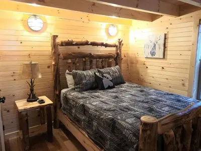 a bedroom with a bed in a log cabin at Queen of Hearts in Rockbridge