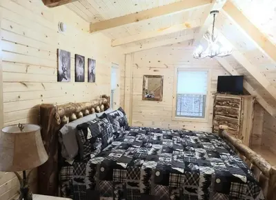 a bedroom with a bed in a log cabin at Queen of Hearts in Rockbridge