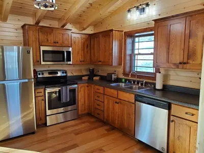 a kitchen with wooden cabinets and stainless steel appliances at Ace of Hearts in Rockbridge