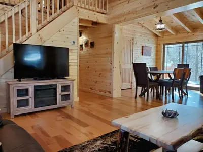 a living room with a large television and a table at Ace of Hearts in Rockbridge