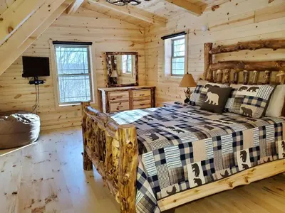 a bedroom with a bed in a log cabin at Ace of Hearts in Rockbridge