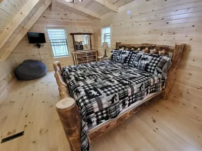 a bedroom with a bed in a log cabin at Jack of Hearts in Rockbridge