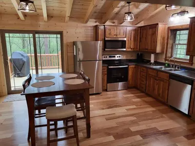 a kitchen with a table with chairs and a refrigerator at Jack of Hearts in Rockbridge
