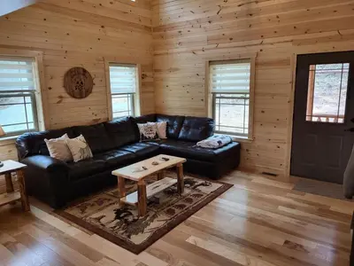 a living room with a black leather couch and a table at Jack of Hearts in Rockbridge