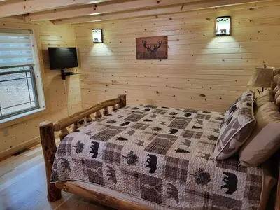 a bedroom with a bed in a log cabin at Jack of Hearts in Rockbridge