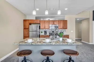 a kitchen with a large island with two bar stools at LAKE VIEWS! 15th Floor Downtown High-Rise | Gym in Cleveland