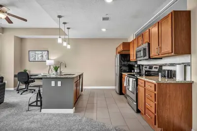 a kitchen with wooden cabinets and a counter top at LAKE VIEWS! 15th Floor Downtown High-Rise | Gym in Cleveland