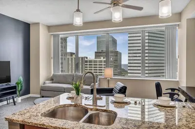a kitchen with a sink and a large window at LAKE VIEWS! 15th Floor Downtown High-Rise | Gym in Cleveland