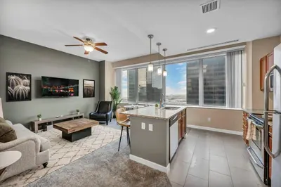 a kitchen and living room with a couch and a table at Downtown Suite w/ Amazing Views in Cleveland