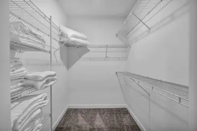 a walk in closet with white walls and white shelves at Downtown Suite w/ Amazing Views in Cleveland