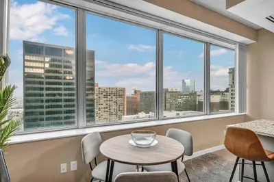 a room with a table and chairs and large windows at Downtown Suite w/ Amazing Views in Cleveland