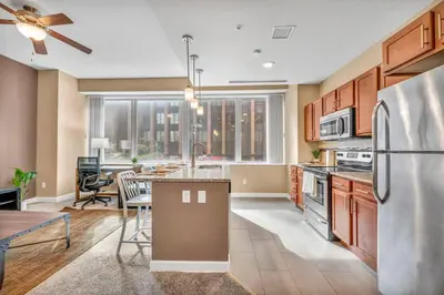 a kitchen with a refrigerator and a dining room at Modern High-Rise Condo in Central Downtown | Gym in Cleveland
