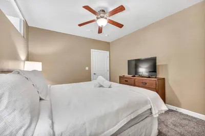 a bedroom with a white bed and a ceiling fan at Modern High-Rise Condo in Central Downtown | Gym in Cleveland