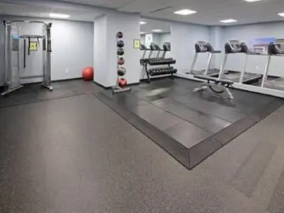 a gym with treadmills and machines in a room at Modern High-Rise Condo in Central Downtown | Gym in Cleveland