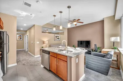 a kitchen with a sink and a living room at Modern High-Rise Condo in Central Downtown | Gym in Cleveland