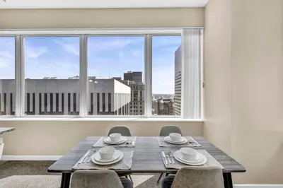 a dining room with a table and chairs and a large window at 21st Floor Penthouse | Amazing Views of Downtown! in Cleveland