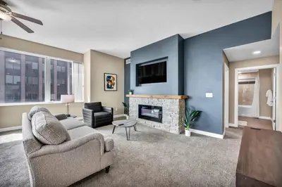 a living room with a couch and a fireplace at 21st Floor Penthouse | Amazing Views of Downtown! in Cleveland