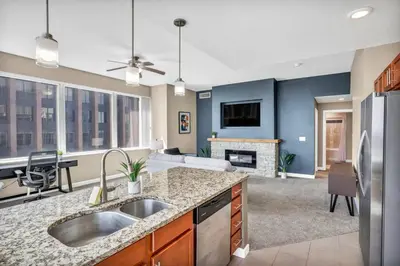 a kitchen with a sink and a living room at 21st Floor Penthouse | Amazing Views of Downtown! in Cleveland