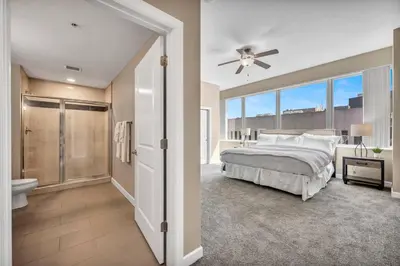 a bedroom with a bed and a bathroom with a shower at 21st Floor Penthouse | Amazing Views of Downtown! in Cleveland