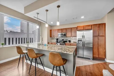 a kitchen with a large island with bar stools at Sky High Suite Downtown w/ Parking Available $ in Cleveland