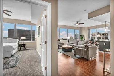 a large bedroom with a bed and a living room at Sky High Suite Downtown w/ Parking Available $ in Cleveland