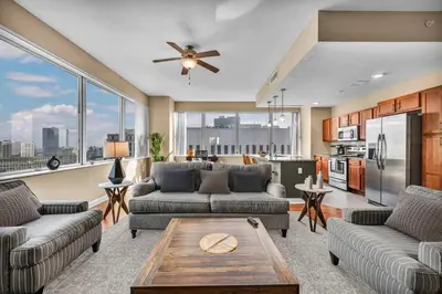 a living room with two couches and a kitchen at Sky High Suite Downtown w/ Parking Available $ in Cleveland