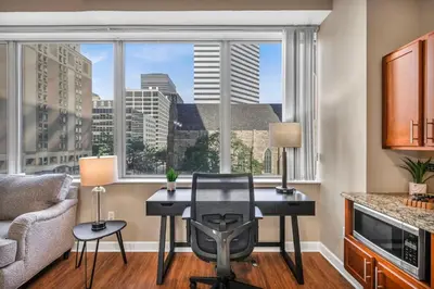 a desk with a chair in a room with a large window at Modern Condo w/ Cathedral Views in Great Location in Cleveland