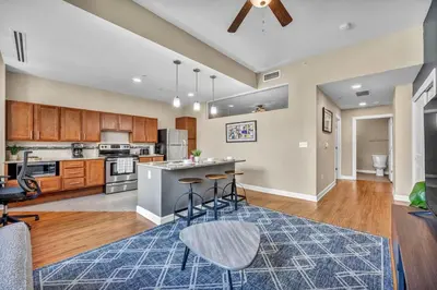 an open kitchen and living room with a ceiling fan at Modern Condo w/ Cathedral Views in Great Location in Cleveland