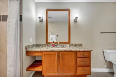 a bathroom with a sink and a mirror at Modern Condo w/ Cathedral Views in Great Location in Cleveland