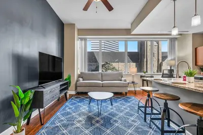 a living room with a couch and a tv at Modern Condo w/ Cathedral Views in Great Location in Cleveland