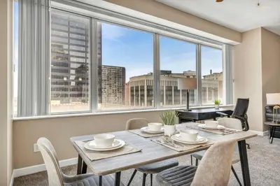 a dining room with a table and chairs and a large window at Luxury Condo w/ Lake Views! Center of Downtown in Cleveland