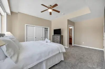 a bedroom with a white bed and a ceiling fan at Luxury Condo w/ Lake Views! Center of Downtown in Cleveland