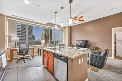 an open kitchen and living room with a view of the city at Luxury High-Rise Condo in Amazing Location | Gym in Cleveland
