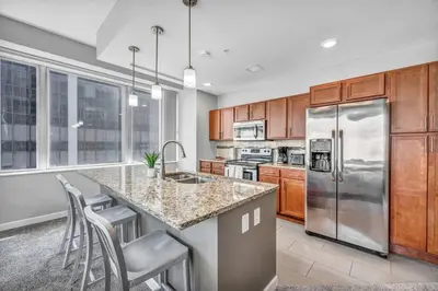 a kitchen with stainless steel appliances and wooden cabinets at Luxury High-rise Condo w/ Views! Heart of Downtown in Cleveland