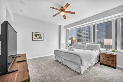 a bedroom with a bed and a flat screen tv at Luxury High-rise Condo w/ Views! Heart of Downtown in Cleveland