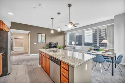 a kitchen and living room with a table and a couch at Luxury High-rise Condo w/ Views! Heart of Downtown in Cleveland