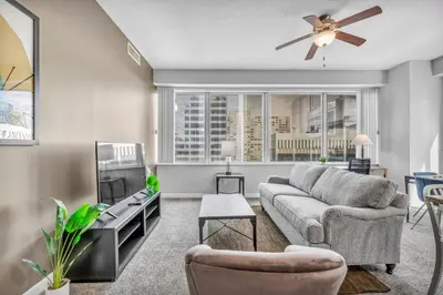 a living room with a couch and a ceiling fan at Luxury High-rise Condo w/ Views! Heart of Downtown in Cleveland