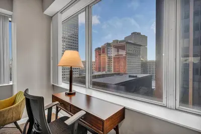 a desk and chairs in a room with a large window at 10th Floor Downtown High-Rise | Gym in Cleveland