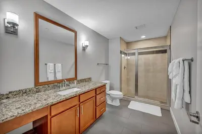 a bathroom with a sink and a toilet and a mirror at 10th Floor Downtown High-Rise | Gym in Cleveland