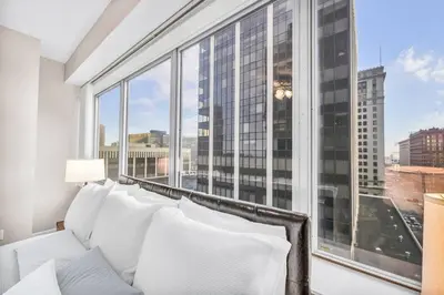 a white couch in a room with a large window at 10th Floor Downtown High-Rise | Gym in Cleveland
