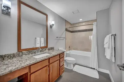 a bathroom with a sink and a tub and a toilet at 10th Floor Downtown High-Rise | Gym in Cleveland
